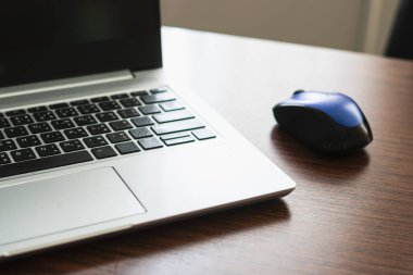 Defterin yanında fare ya da tahta masadaki dizüstü bilgisayar..