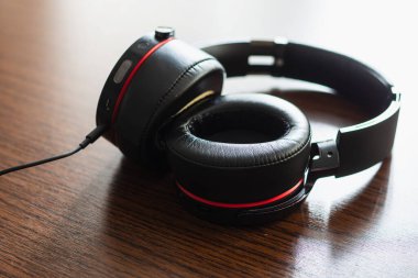 Ahşap masada siyah kulaklıklar..