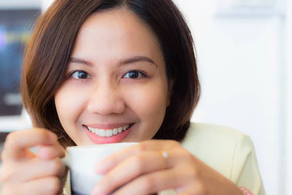 一个美丽的亚洲女孩拿着一杯茶 面带微笑 — 图库照片