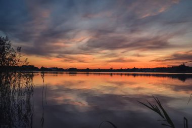 Güzel renkli sabah manzarası. Polonya gölünün üzerinde harika bir gökyüzü.