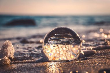 Soyut deniz kenarı fikri. Deniz manzarası cam bir küre içinde bulanık bir arka plan ile tutulur..