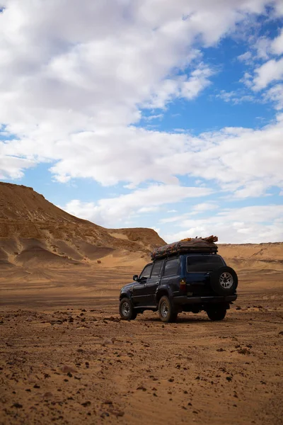 SUV, araba, Sahra 'daki dağların yakınındaki off-road çöl safarisi..