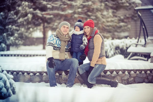 Happy young family portrait on winter surrounded by snow. — Stock Photo, Image