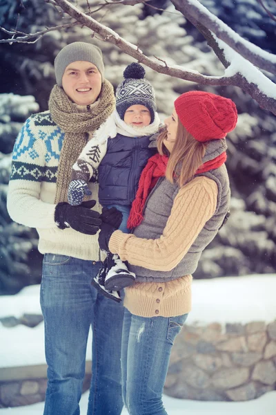 Happy young family portrait on winter surrounded by snow. — Stock Photo, Image