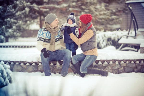 Gelukkig jonge familie portret op winter omringd door sneeuw. — Stockfoto