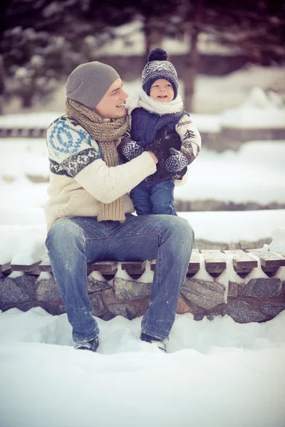 Happy young family portrait on winter surrounded by snow. — Stock Photo, Image