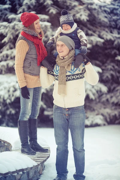 Happy young family portrait on winter surrounded by snow. — Stock Photo, Image