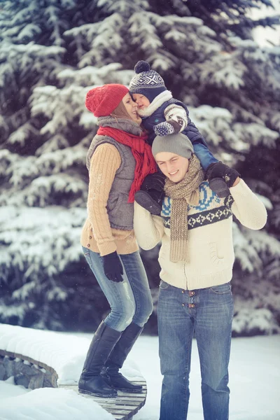 Gelukkig jonge familie portret op winter omringd door sneeuw. — Stockfoto