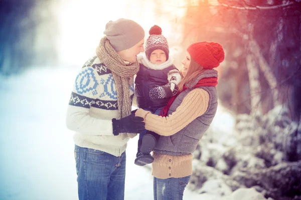 Gelukkig jonge familie portret op winter omringd door sneeuw. — Stockfoto