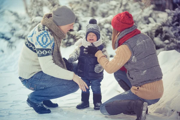 Happy young family portrait on winter surrounded by snow. — Stock Photo, Image