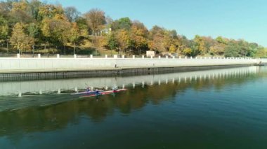 Kanolar üzerinde kürek çeken kürek çekenler nehir kıyısında