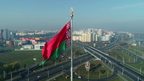 Drapeau biélorusse agitant le ciel bleu et le paysage urbain de Minsk par une matinée ensoleillée — Video