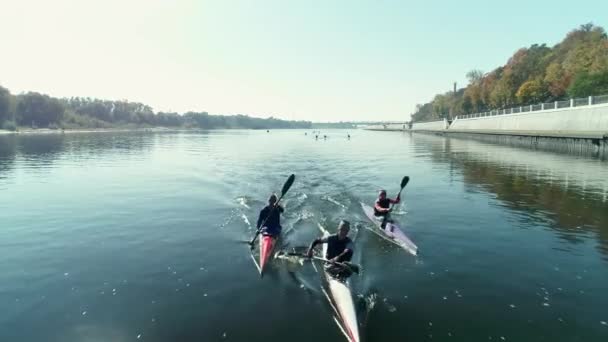 晴れた日には市内の堤防沿いの川を漕ぐカヤックの漕ぎ手 — ストック動画