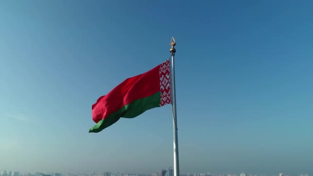 Белорусский флаг, развевающийся над голубым небом в солнечное утро — стоковое видео