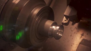 CNC değirmen makinesi çalışıyor. Atölyedeki cnc torna makinesini döndürmek için çelik metal işleme aracı kesiliyor
