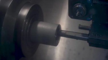 CNC değirmen makinesi çalışıyor. Atölyedeki cnc torna makinesini döndürmek için çelik metal işleme aracı kesiliyor