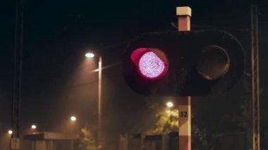Gece demiryolu geçidinde yanıp sönen kırmızı ışıklar.