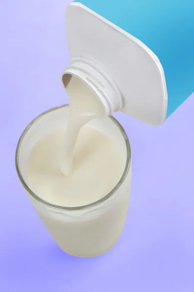 Pouring milk on glass — Stock Photo, Image