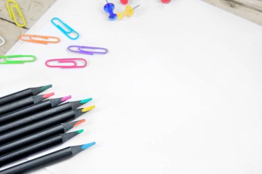 Boş defter kağıdı, kalem, ataç, fotokopi alanı, düz masa.