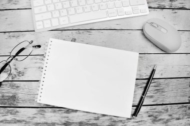 Masasında not defteri, bilgisayar klavyesi ve kalem olan bir ofis masası.