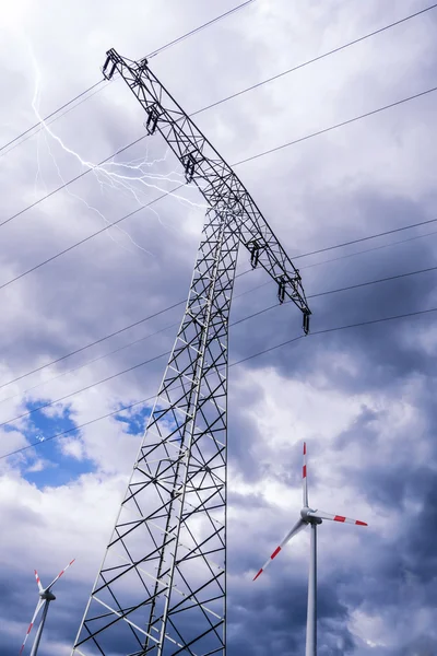 Elektriska tower och vindkraftgenerator Stockfoto