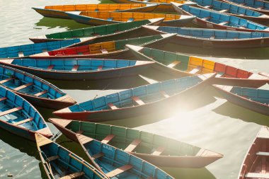 Nepal, Pokhara 'daki Phewa Gölü' nde güneş ışığı altında çok renkli ahşap tekneler.