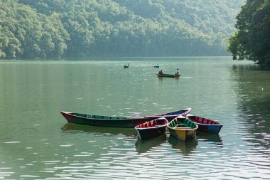 POKHARA - NEPAL, 30 Mayıs 2016: Phewa Gölü 'nde turistlerle yüzen tekneler