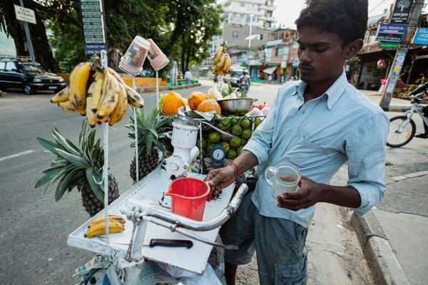 POKHARA - NEPAL, 30 Mayıs 2016: Tanımlanamayan bir meyve suyu satıcısı meyve suyu üretiyor — Stok fotoğraf