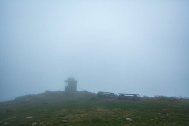 Dağların tepesinde yoğun sis altında açık hava yemek alanı, Ukrayna Karpatları