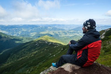 Bir adam dağların manzarasına hayran, Ukraynalı Karpatlar.