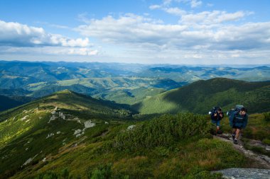 CARPATHIANS, UKRAINE - 13 Ağustos 2016: Sırt çantalı iki genç yokuş yukarı, Karpatya dağları, Ukrayna