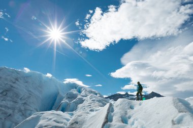Perito Moreno Buzulu 'nun karlı buz oluşumunun üzerinde duran bir adam.
