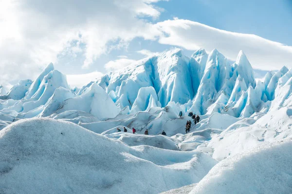 LOS GLACIARES NATIONAL Park, ARGENTINA - 2019. június 26.: Az emberek a Perito Moreno gleccser havas jégképződésének rétegei között járnak — Stock Fotó