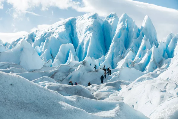 LOS GLACIARES NATIONAL PARK, ARGENTINA - JANEIRO 26, 2019: As pessoas caminham entre as camadas de formação de gelo nevado do Glaciar Perito Moreno — Fotografia de Stock