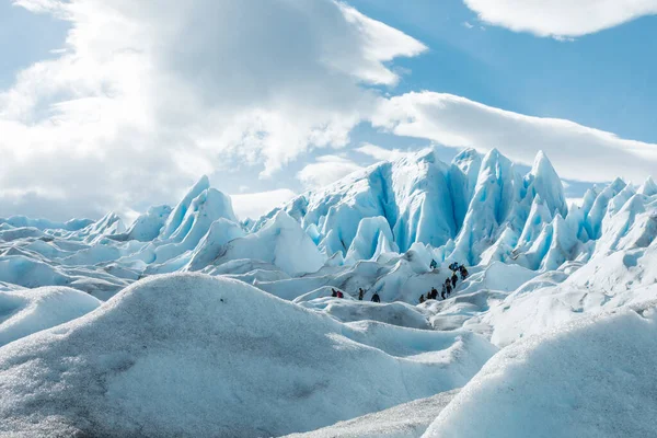 LOS GLACIARES NATIONAL Park, ARGENTINA - 2019. június 26.: A turisták a Perito Moreno gleccser havas jégképződési rétegei között sétálnak — Stock Fotó