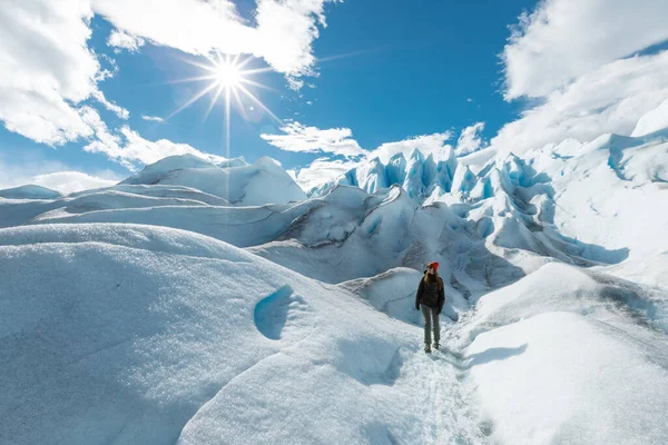 Egy nő sétál a Perito Moreno gleccser jégképződésén, és balra néz. — Stock Fotó