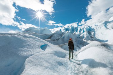 Perito Moreno Buzulu 'nun buz oluşumunda bir kadın duruyor ve gülümsüyor.