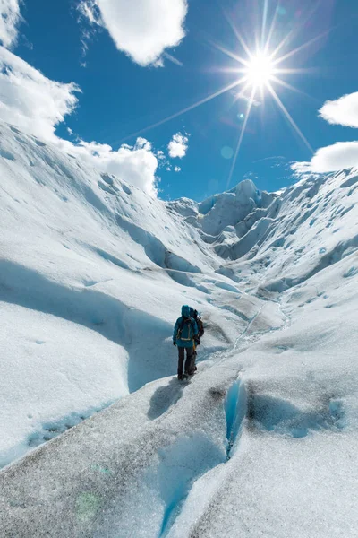 LOS GLACIARES NATIONAL Park, ARGENTINA - 2019. június 26.: Két túrázó sétál a Perito Moreno gleccser jeges túraútvonalán — Stock Fotó