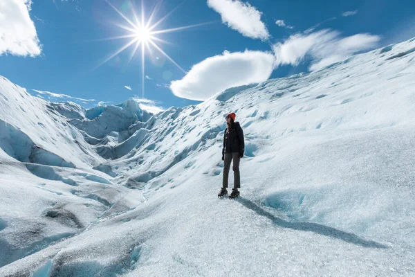 Een vrouw die op de ijsformatie van de Perito Moreno gletsjer staat en links omhoog kijkt. — Stockfoto