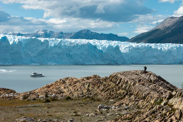 Un uomo in piedi sulla formazione rocciosa e scattare una foto del ghiacciaio Perito Moreno — Foto Stock
