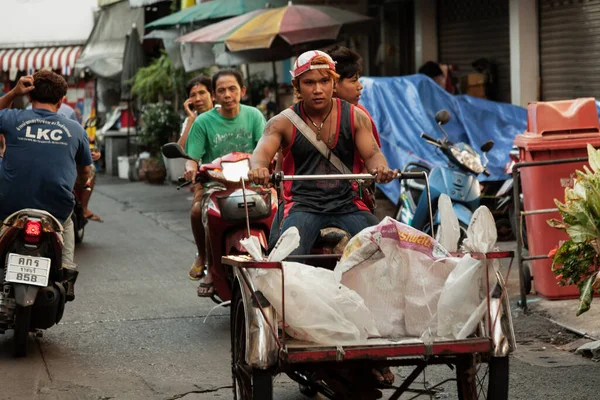 BANGKOK, THAILAND - 3 Mayıs 2014: Genç bir adam bağlı bir arabayla bisiklete biniyor