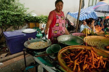 BANGKOK, THAILAND - 3 Mayıs 2014: Taylandlı kadın Bangkok 'ta sokak yemeği hazırlıyor
