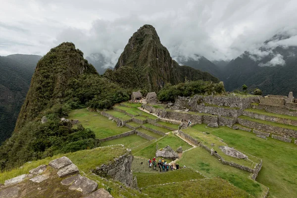 MACHU PICCHU, PERU - 9 MARZO 2019: Un gruppo di turisti si riposa su una delle terrazze di Machu Picchu — Foto Stock