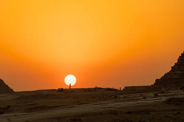 The silhouette of a man walking up a hill at sunset in Giza, Egypt — ストック写真