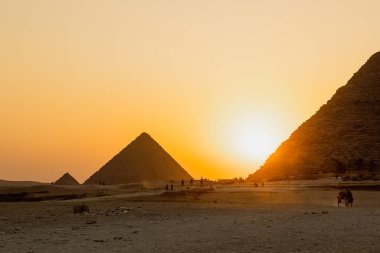 The sun is going down behind the pyramid of Giza, Egypt