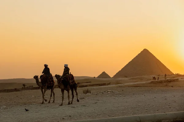 2018年埃及，开罗- 11月17日：乘坐骆驼游览金字塔的人 — 图库照片