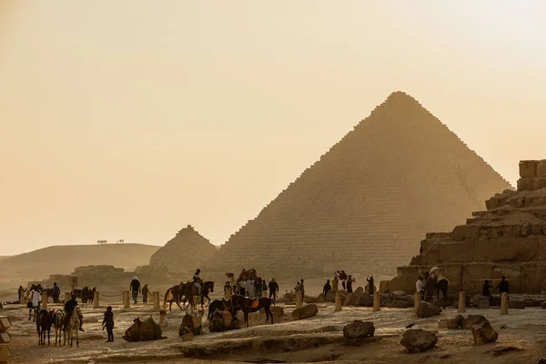 CAIRO, EGITO-NOVEMBRO 17, 2018: Turistas montam camelos e cavalos perto das pirâmides de Gizé — Fotografia de Stock