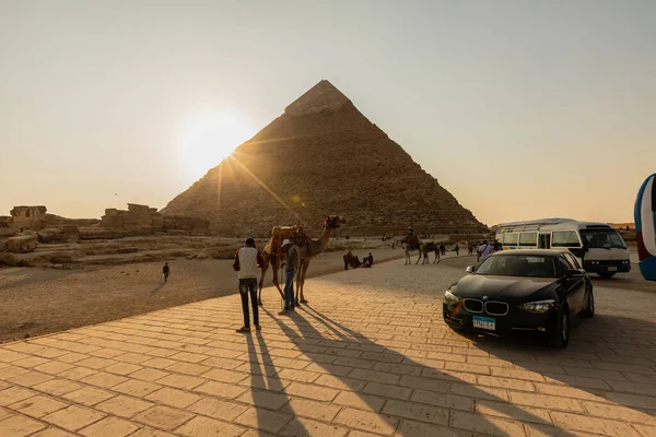 CAIRO, EGYPT- NOVEMBER 17, 2018: Vehicles, people and camels near pyramids of Giza — стокове фото