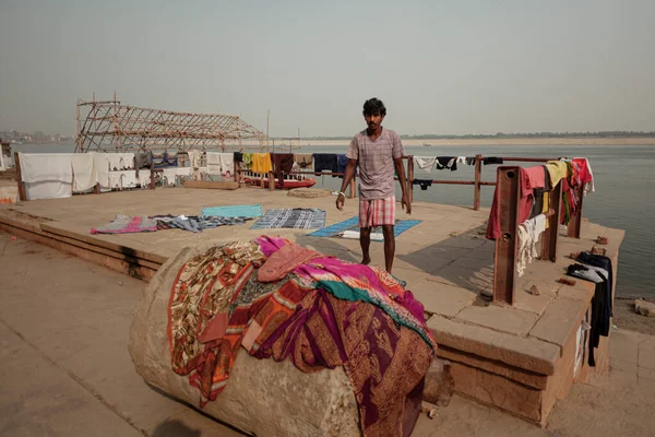 VARANASI, INDIA - NOVEMBER 12, 2014: Man dries laundry on the ghats — стоковое фото