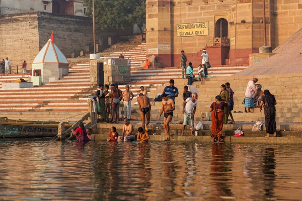 VARANASI, INDIA - NOVEMBER 12, 2014:Pilgrims visit Varanasi in order to purify themselves by bathing in the River Ganges at sunrise — Foto Stock